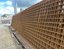 Stahlgitter gestapelt auf Pflasterfläche im Freien, Baumaterial für Bewehrung bei Bauprojekten.