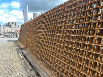 Stahlgitter gestapelt auf Pflasterfläche im Freien, Baumaterial für Bewehrung bei Bauprojekten. Stahlgitter gestapelt auf Pflasterfläche im Freien, Baumaterial für Bewehrung bei Bauprojekten.