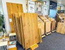 Ausstellung von Holzfußböden in verschiedenen Farben und Größen, ordentlich präsentiert im Geschäft