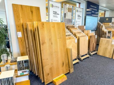 Ausstellung von Holzfußböden in verschiedenen Farben und Größen, ordentlich präsentiert im Geschäft Ausstellung von Holzfußböden in verschiedenen Farben und Größen, ordentlich präsentiert im Geschäft