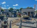 Gartencenter zeigt Pflastersteine, Brunnen und Dekoartikel im Außenbereich unter klarem Himmel