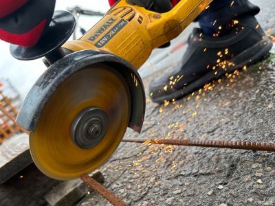 Winkelschleifer schneidet Metallrohr, Funken fliegen – zeigt Einsatz von Maschinen im Bauhandwerk. Winkelschleifer schneidet Metallrohr, Funken fliegen – zeigt Einsatz von Maschinen im Bauhandwerk.
