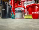 Eimer und Werkzeuge stehen bereit auf Lagerboden, zeigen Bauchemieprodukte für professionelle Anwendungen