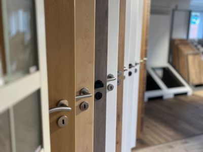 Mehrere Holztüren in verschiedenen Farben und Designs nebeneinander ausgestellt zur Auswahl im Showroom