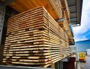 Holzlatten ordentlich gestapelt unter Dach, zeigen Lagerung von Baumaterialien für spätere Verwendung