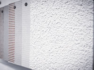 Wand zeigt verschiedene Putzmuster mit unterschiedlichen Texturen, Vergleich von Oberflächen für Bauprojekte