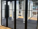 Modernes Büro mit Glaswänden und Türen, klare Linien und helle Beleuchtung zeigen funktionale Raumgestaltung