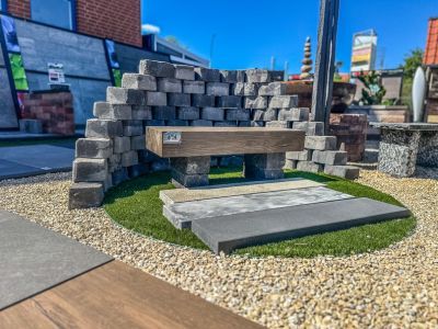 Außenbereich mit Pflastersteinen, Kieswegen und Kunstrasen, zeigt Gestaltungselemente für Gartenbau
